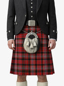 Person wearing a red tartan kilt with a black jacket and white shirt on a white background