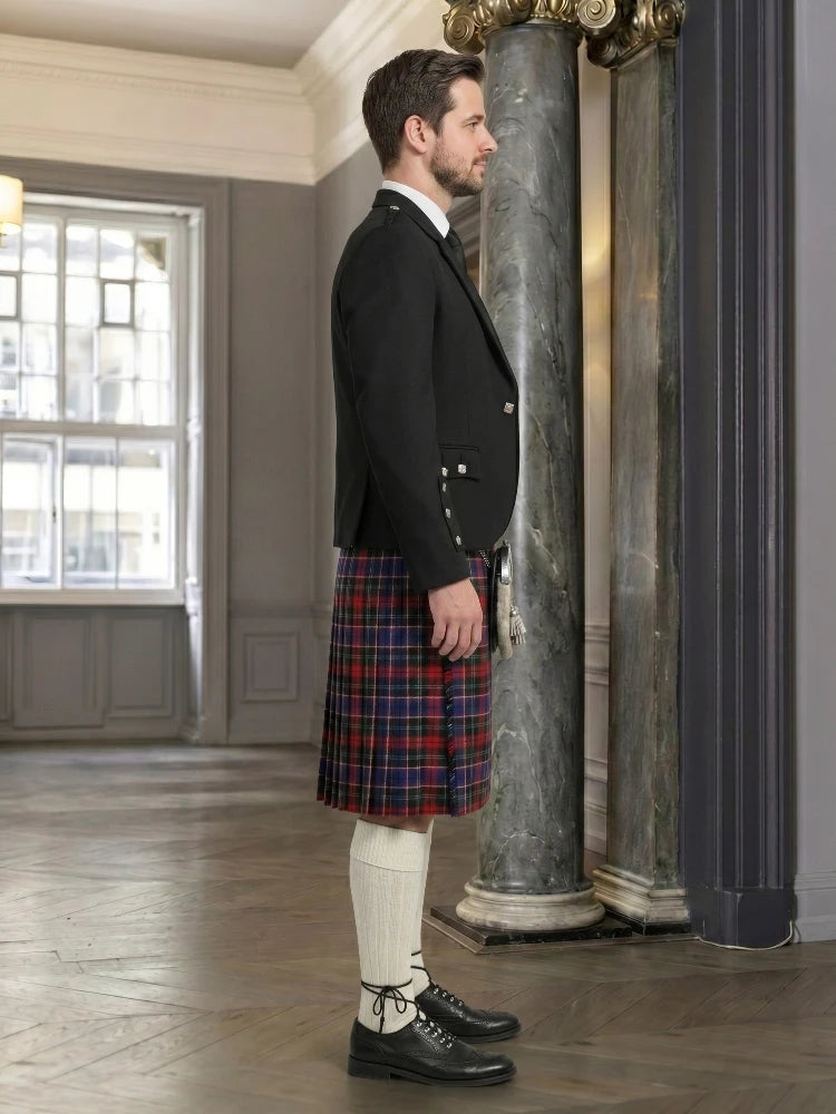 Man wearing a black jacket and red plaid kilt in an elegant room with marble columns.