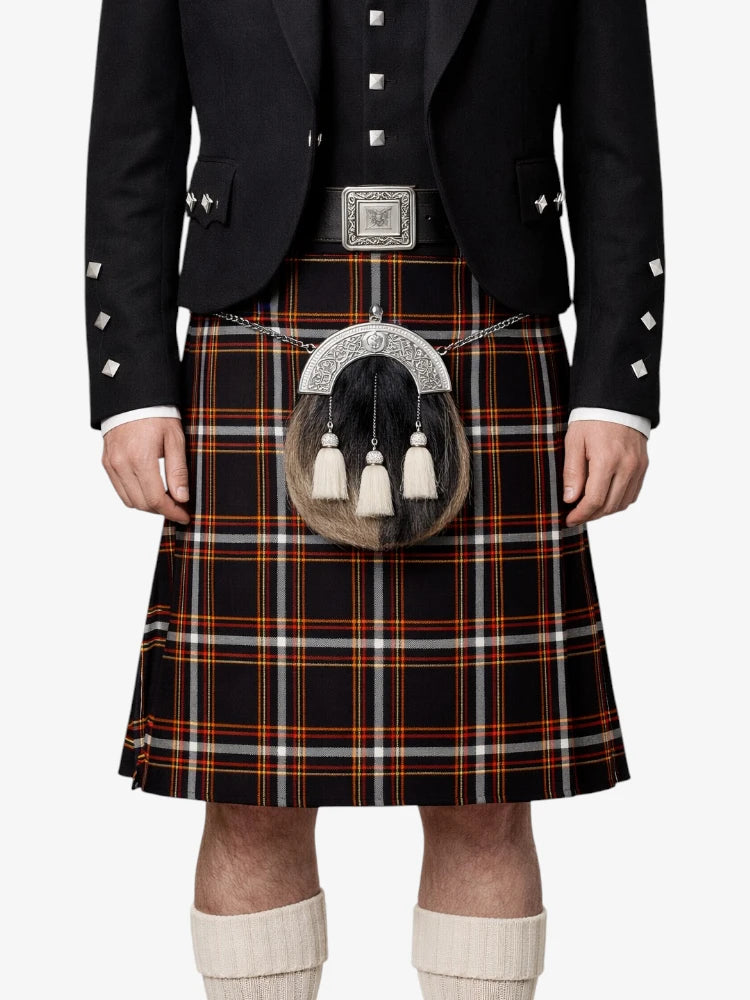Person wearing a traditional Scottish kilt with a tartan pattern on a white background