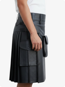 Person wearing a black pleated kilt on a white background