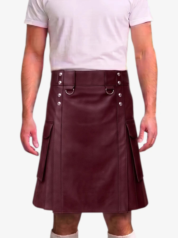 A person wearing a dark burgundy faux-leather kilt with silver-tone metal hardware, belt loops, and side pockets, paired with a light pink t-shirt against a plain white background.