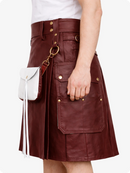 Burgundy leather skirt with gold buttons and a white handbag on a white background