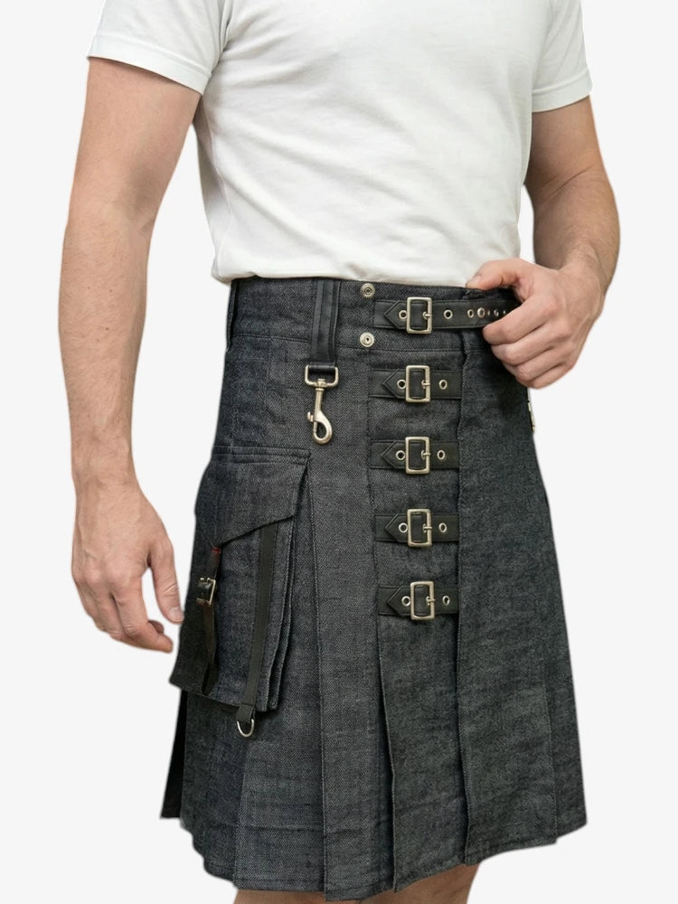 Person wearing a denim kilt with metal buckles on a white background
