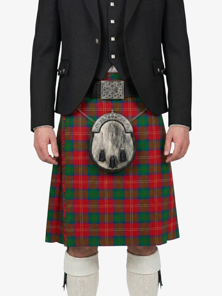 Person wearing a red and green plaid kilt with a black jacket on a white background