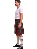 A man shown in profile wearing a dark brown leather kilt with red and purple lining, a white t-shirt, white knee-high socks, and black shoes, against a plain white background.