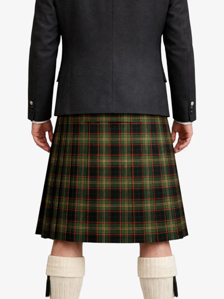 Person wearing a dark jacket and green plaid kilt on a white background