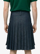 Person wearing a green shirt and pleated navy skirt on a plain background