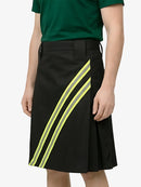Black skirt with yellow stripes worn by a person on a white background