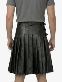 Person wearing a black pleated leather skirt on a white background