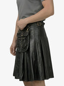 Person wearing a black leather skirt with a matching bag on a white background