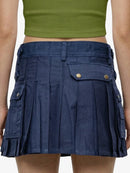 Navy pleated skirt with gold buttons worn by a person, on a plain background