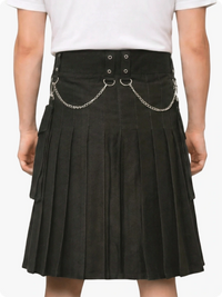 Black pleated skirt with chain details worn by a person on a white background
