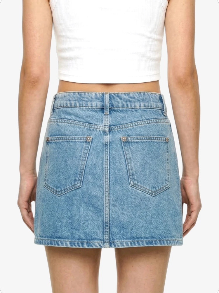 Light blue denim skirt worn by a person on a white background
