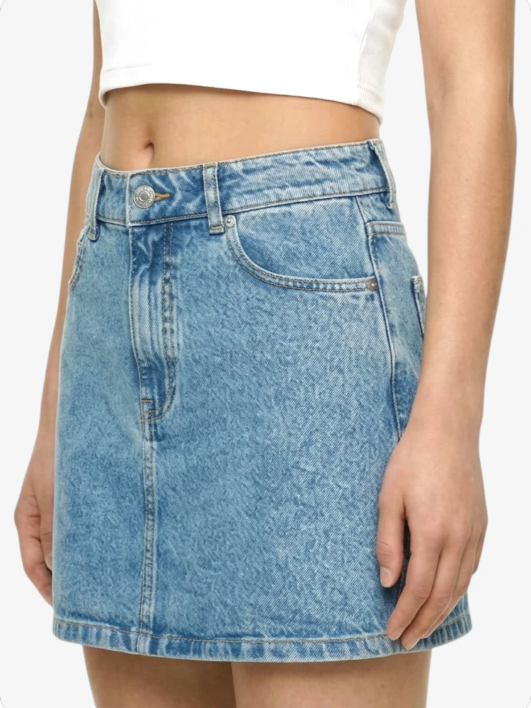 Blue denim skirt worn by a person on a white background