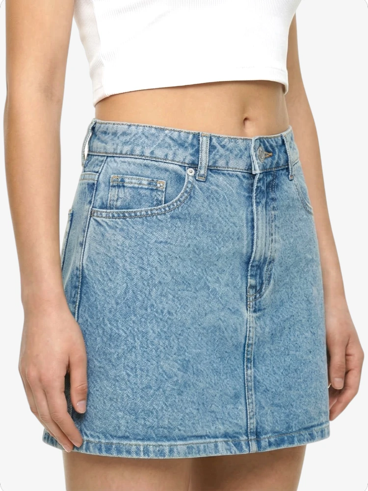 Light blue denim skirt worn by a person on a white background