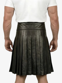 Person wearing a black pleated leather skirt on a white background