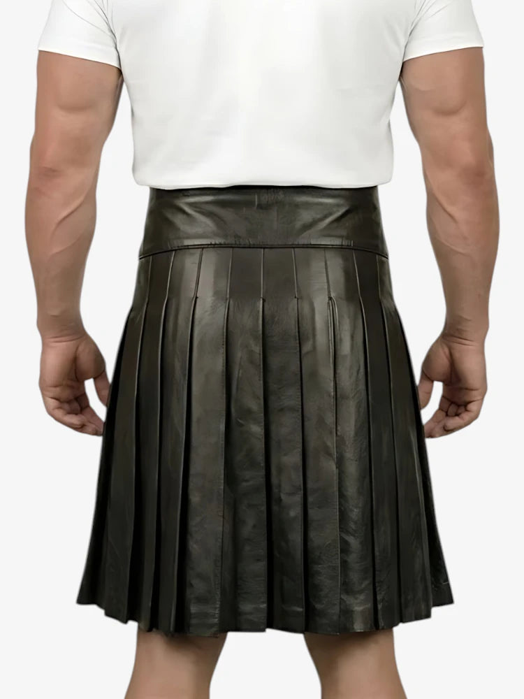 Person wearing a black pleated leather skirt on a white background
