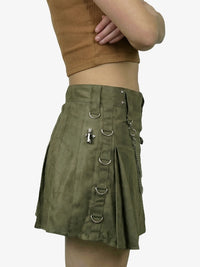Green skirt with metal rings and a person wearing it on a white background