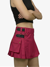 Person wearing a black crop top and red skirt with black accents on a white background