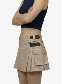 Person wearing a beige cargo skirt with black accents on a white background