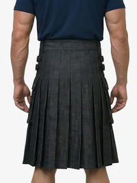 Person wearing a navy shirt and black pleated kilt on a white background