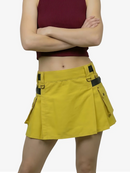 Person wearing a yellow skirt with black straps on a white background
