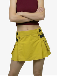 Person wearing a yellow skirt with black straps on a white background