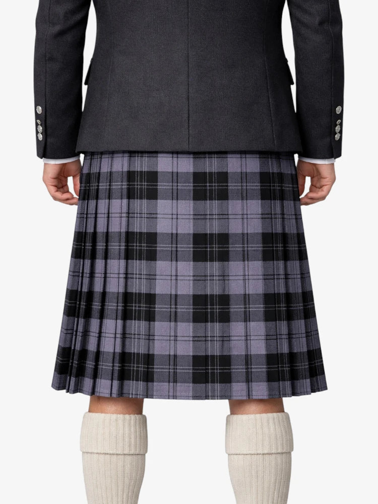Person wearing a gray plaid kilt with a dark jacket on a white background