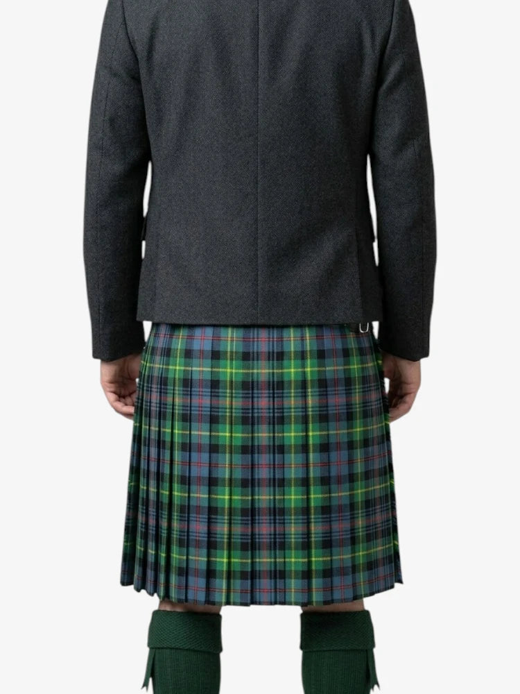 Person wearing a dark jacket and green plaid kilt on a white background