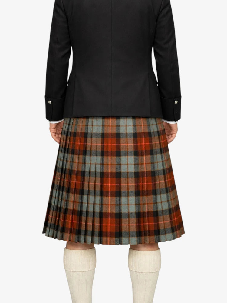 Person wearing a black jacket and plaid kilt on a white background