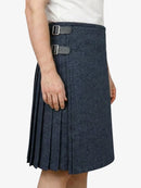 Person wearing a navy pleated skirt with a white background