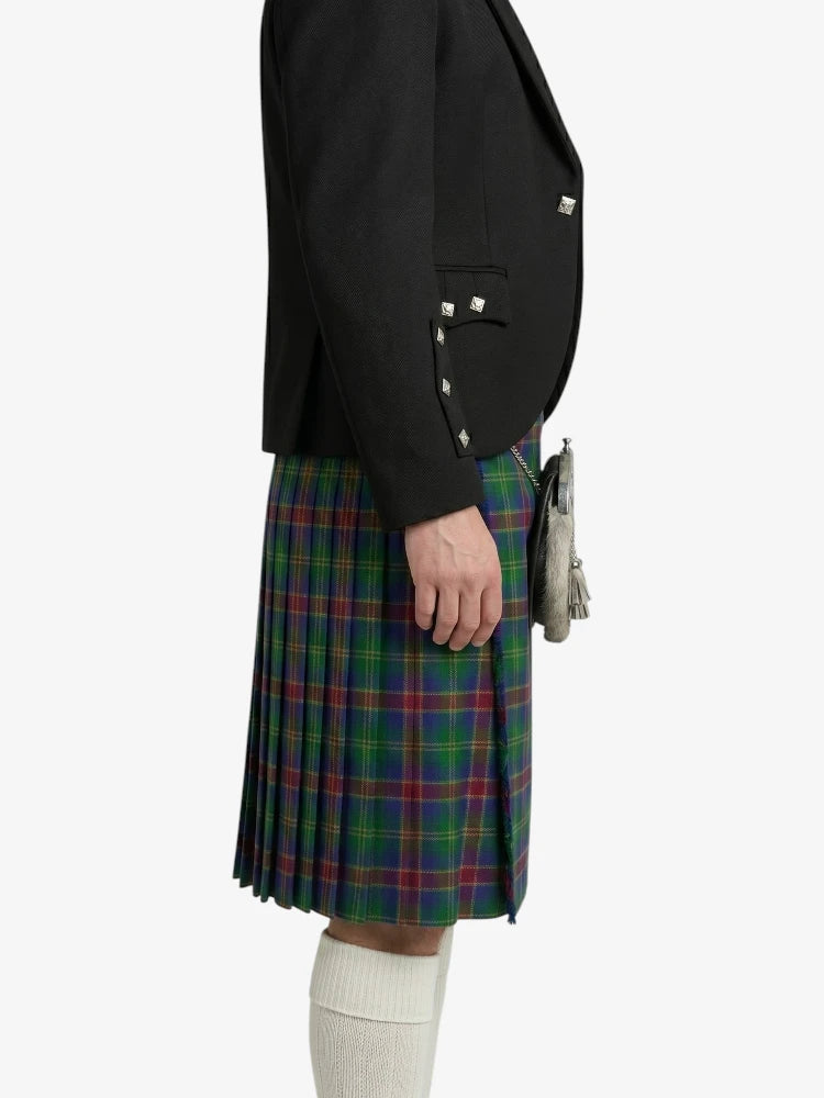 Person wearing a black blazer and plaid kilt on a white background