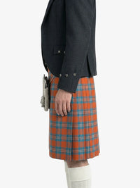 Person wearing a dark jacket and orange plaid kilt on a white background