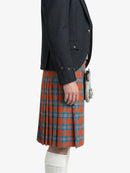 Person wearing a dark jacket and red plaid kilt on a white background