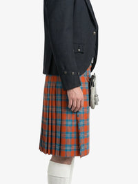 Person wearing a dark jacket and red plaid kilt on a white background