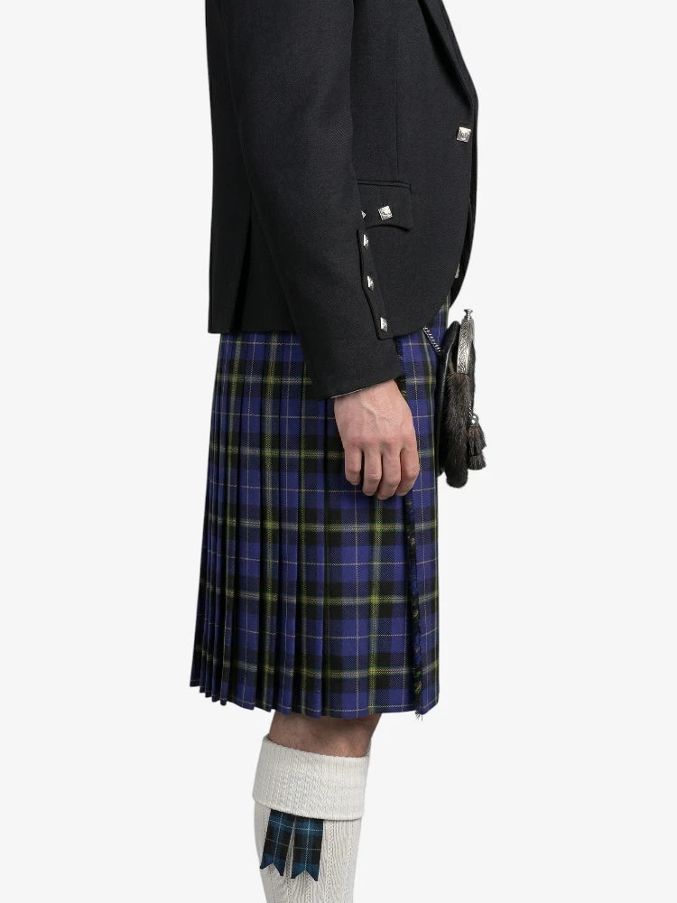 Person wearing a dark jacket and blue plaid kilt on a white background