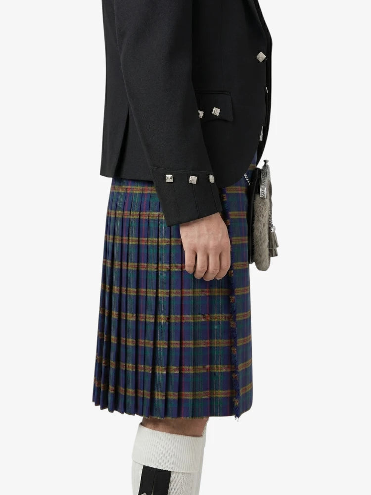 Person wearing a black jacket and plaid kilt on a white background