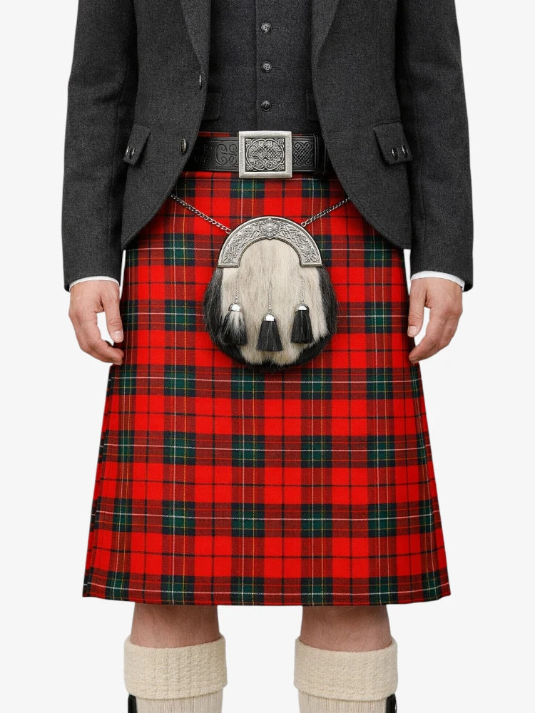 Person wearing a red plaid kilt with a gray jacket and white socks on a white background