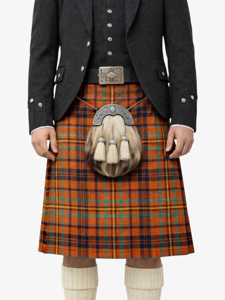 Person wearing a traditional Scottish kilt with a jacket and sporran on a white background