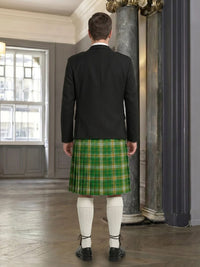 Man wearing a black jacket and green plaid kilt in an indoor setting.