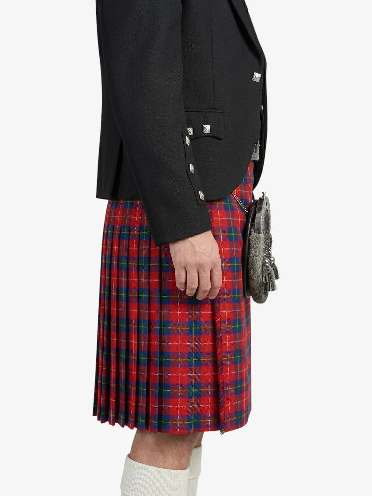 Person wearing a black blazer and red plaid kilt on a white background