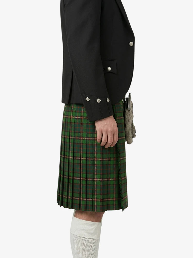 Person wearing a black jacket and green plaid kilt on a white background