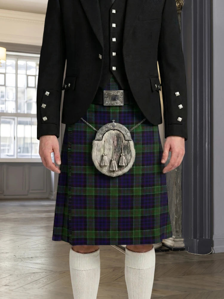 Person wearing a traditional Scottish kilt with a jacket indoors.