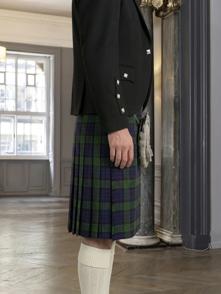 Person wearing a black jacket and plaid kilt in an indoor setting.