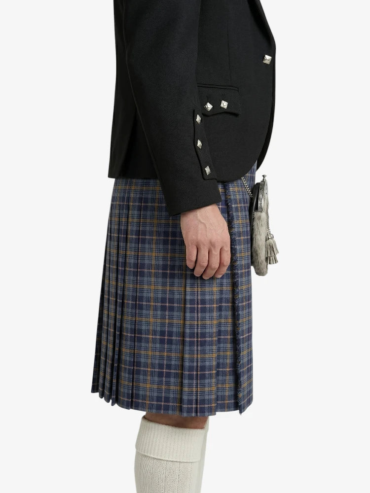 Person wearing a black jacket and plaid kilt on a white background