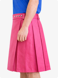 Pink skirt with studded details worn by a person on a white background