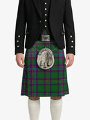Person wearing a green plaid kilt with a black jacket on a white background