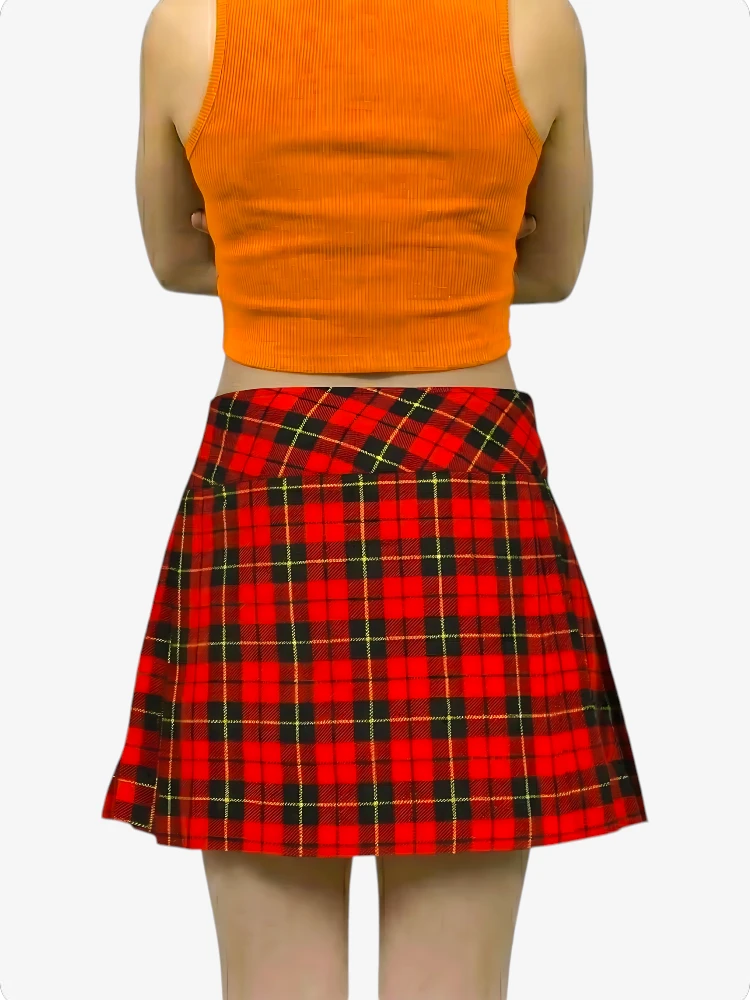 Person wearing an orange crop top and red plaid skirt on a white background