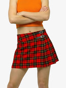 Person wearing an orange top and red plaid skirt on a white background