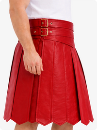Red leather skirt with gold buckles worn by a person on a white background